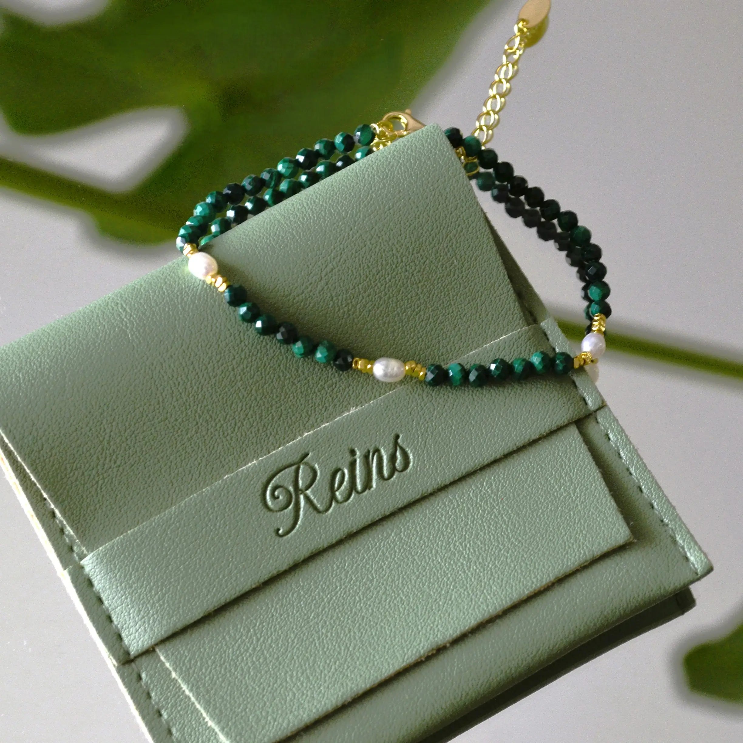 Bratara reglabila cu inchidere din argint 925, placat cu aur de 14k. Pietre semipretioase naturale precum Malachit si Perle , cu elemente din argint. Colectia Terra Wave de la Reins. 02R01-0006 - cu vedere in detaliu