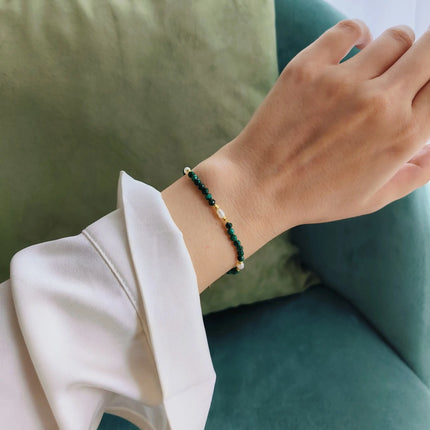 Bratara reglabila cu inchidere din argint 925, placat cu aur de 14k. Pietre semipretioase naturale precum Malachit si Perle , cu elemente din argint. Colectia Terra Wave de la Reins. 02R01-0006 - cu vedere pe model