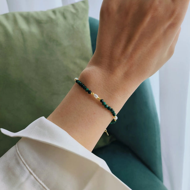 Bratara reglabila cu inchidere din argint 925, placat cu aur de 14k. Pietre semipretioase naturale precum Malachit si Perle , cu elemente din argint. Colectia Terra Wave de la Reins. 02R01-0006 - cu vedere pe model 1