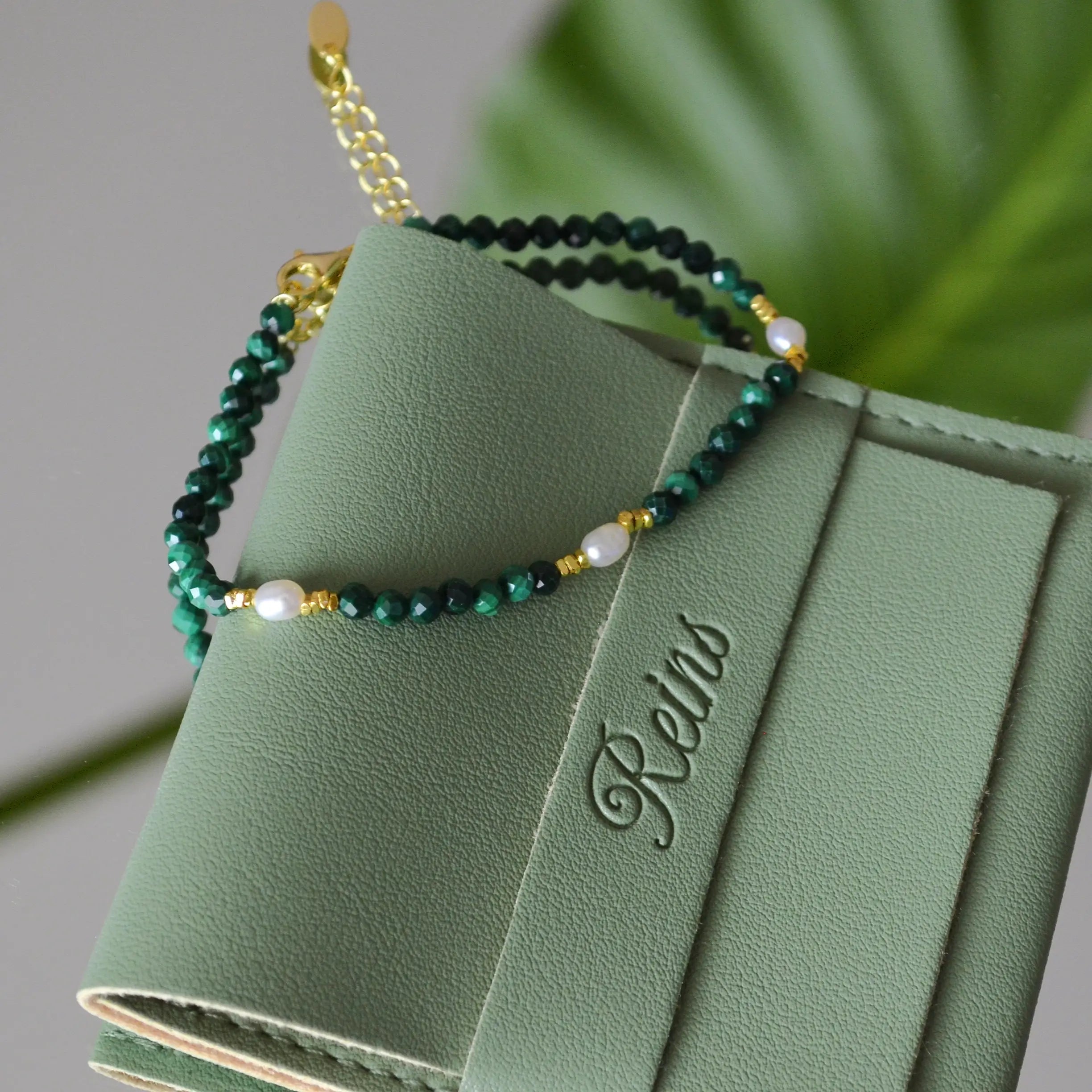 Bratara reglabila cu inchidere din argint 925, placat cu aur de 14k. Pietre semipretioase naturale precum Malachit si Perle , cu elemente din argint. Colectia Terra Wave de la Reins. 02R01-0006 - cu vedere in detaliu